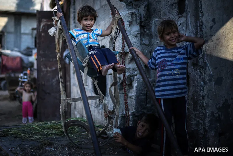 A picture taken on July 31, 2013 shows Palestinian children playing outside their homes in Jabalia refugee camp northern Gaza Strip. Photo by Mahmoud Hamda
