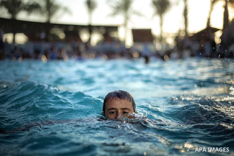 A picture taken on August 10, 2013 shows Palestinian boys swimming at a pool in Gaza City. Photo by Mahmoud Hamda
