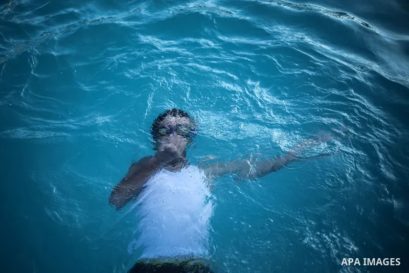 A picture taken on August 10, 2013 shows A Palestinian boy swimming at a pool in Gaza City. Photo by Mahmoud Hamda