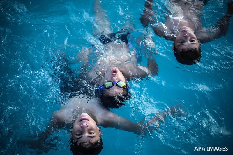 A picture taken on August 10, 2013 shows Palestinian boys swimming at a pool in Gaza City. Photo by Mahmoud Hamda