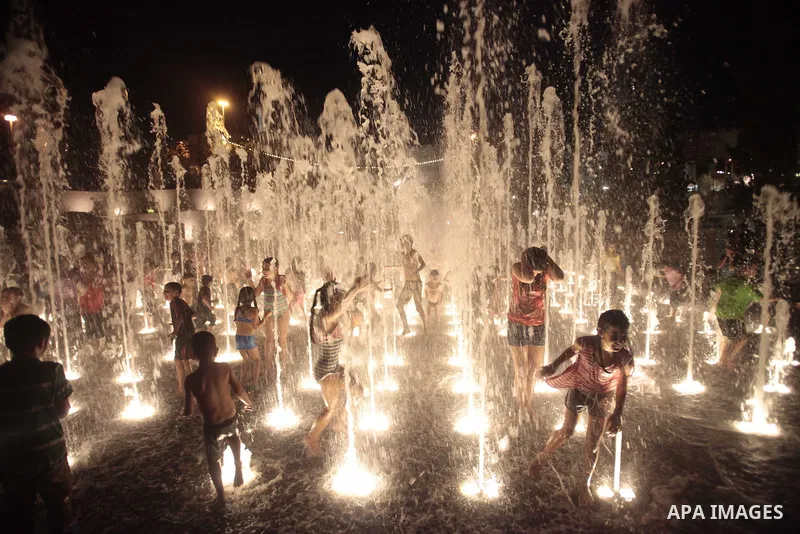 Palestinian children enjoy themselves with water in public parks founded by Israeli municipality near the wall of Jerusalem in the old town, on Aug. 20, 2013. Photo by Saeed Qaq