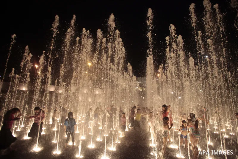 Palestinian children enjoy themselves with water in public parks founded by Israeli municipality near the wall of Jerusalem in the old town, on Aug. 20, 2013. Photo by Saeed Qaq