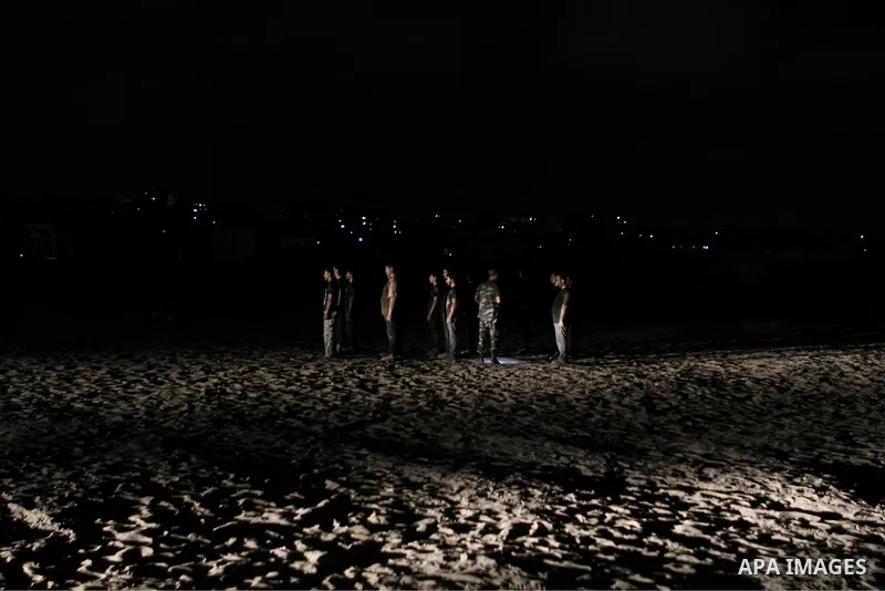 Palestinian youths take part in a night military-style exercises run by militants from the al-Nasser Brigades, an armed wing of the Popular Resistance Committees (PRC), at their training camp in Gaza City, Tuesday, Aug....