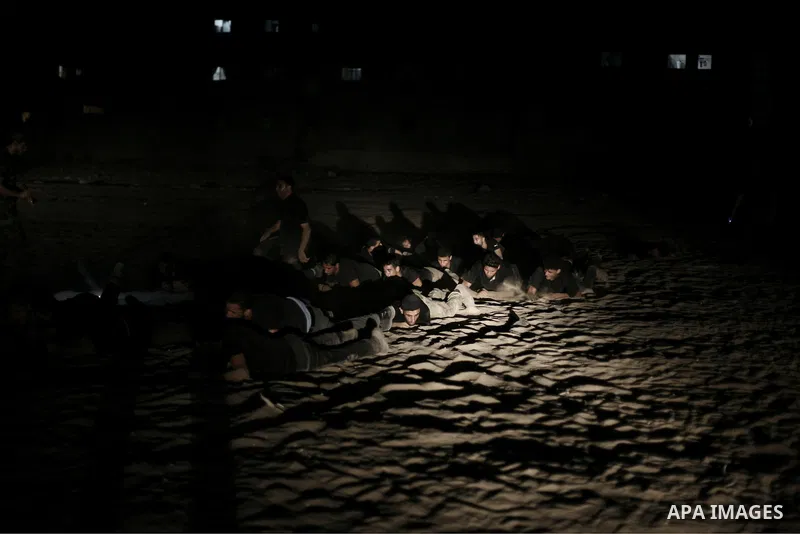 Palestinian youths take part in a night military-style exercises run by militants from the al-Nasser Brigades, an armed wing of the Popular Resistance Committees (PRC), at their training camp in Gaza City, Tuesday, Aug....