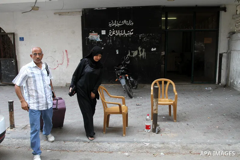 Palestinians walk past the office of the Ministry of Civil affairs following register for travel throw the Beit Hanoun crossing (Erez), in Gaza City Aug 21, 2013. Israel and the Palestinians have has agreed on temporaril...