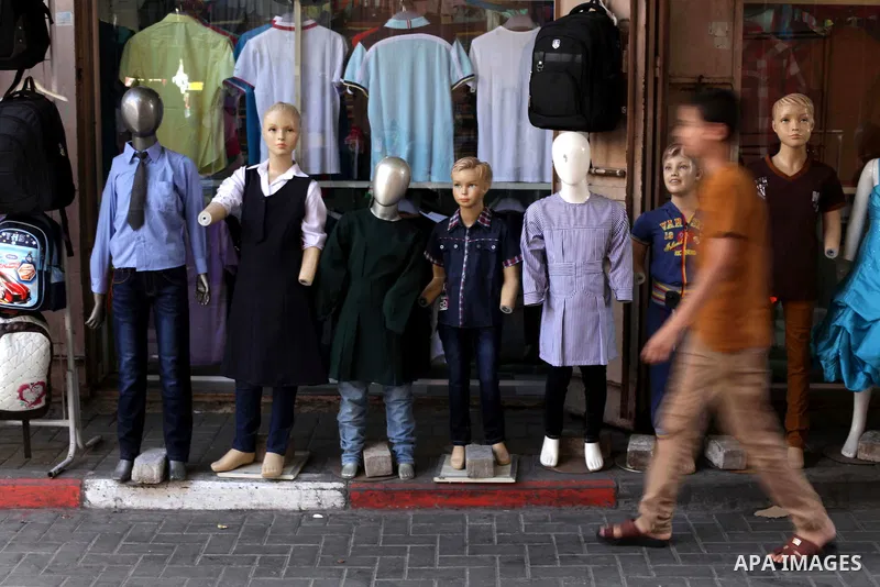 Palestinians shop during preperation for the new school year at a market in Gaza City on Aug 21, 2013. Palestinian Ministry of Education announced the 25 August is the first day of new school year in the West Bank and Ga...
