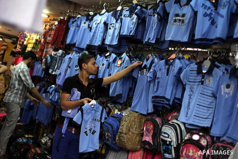 Palestinians shop during preperation for the new school year at a market in Gaza City on Aug 21, 2013. Palestinian Ministry of Education announced the 25 August is the first day of new school year in the West Bank and Ga...
