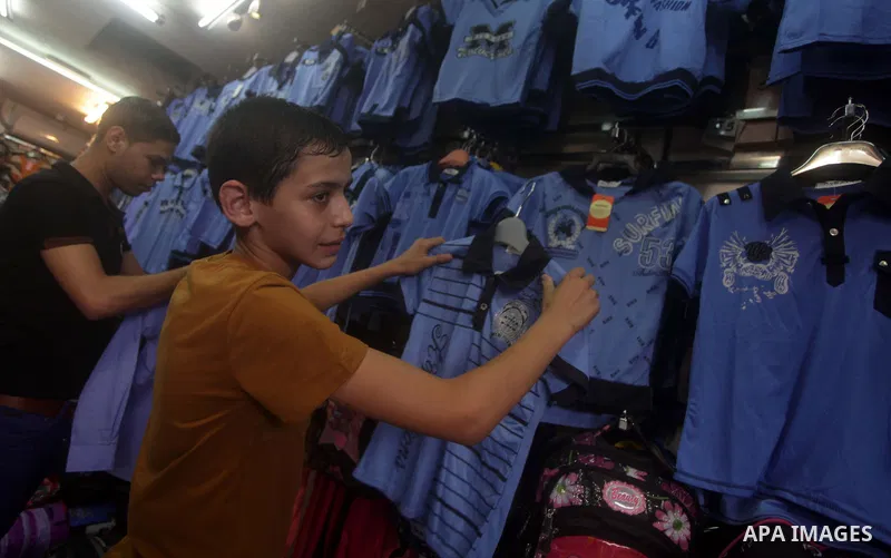 Palestinians shop during preperation for the new school year at a market in Gaza City on Aug 21, 2013. Palestinian Ministry of Education announced the 25 August is the first day of new school year in the West Bank and Ga...