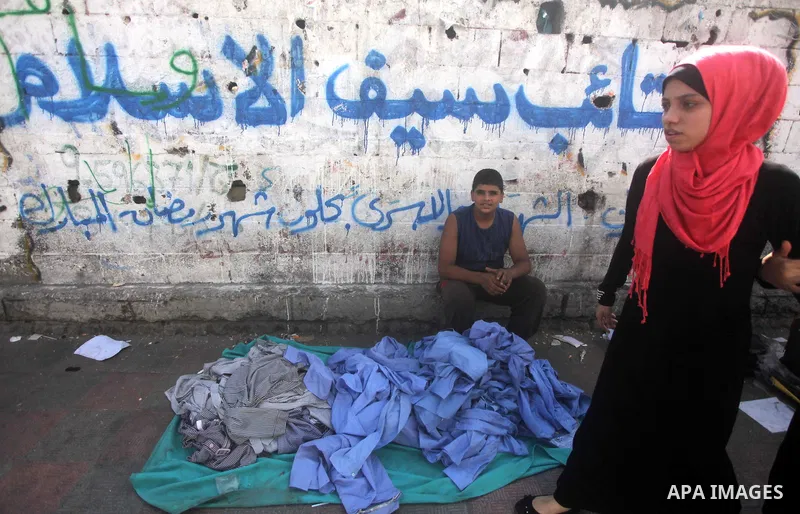 Palestinians shop during preperation for the new school year at a market in Gaza City on Aug 21, 2013. Palestinian Ministry of Education announced the 25 August is the first day of new school year in the West Bank and Ga...