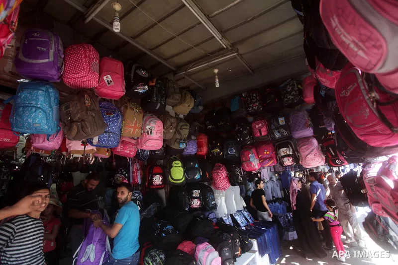 Palestinians shop during preperation for the new school year at a market in Gaza City on Aug 21, 2013. Palestinian Ministry of Education announced the 25 August is the first day of new school year in the West Bank and Ga...