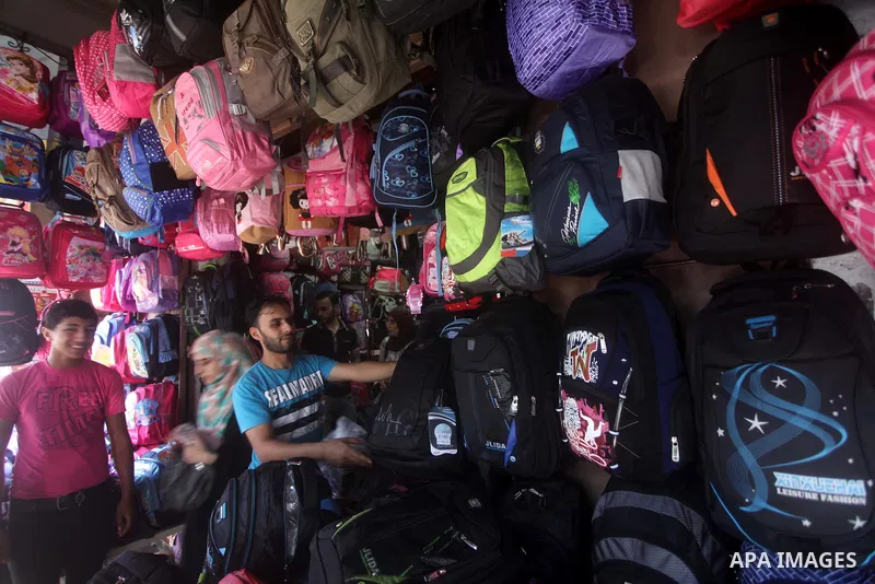 Palestinians shop during preperation for the new school year at a market in Gaza City on Aug 21, 2013. Palestinian Ministry of Education announced the 25 August is the first day of new school year in the West Bank and Ga...