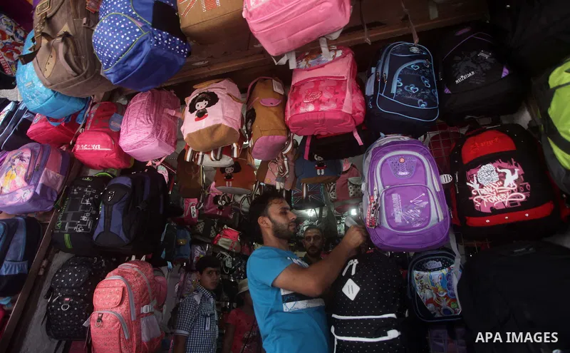 Palestinians shop during preperation for the new school year at a market in Gaza City on Aug 21, 2013. Palestinian Ministry of Education announced the 25 August is the first day of new school year in the West Bank and Ga...