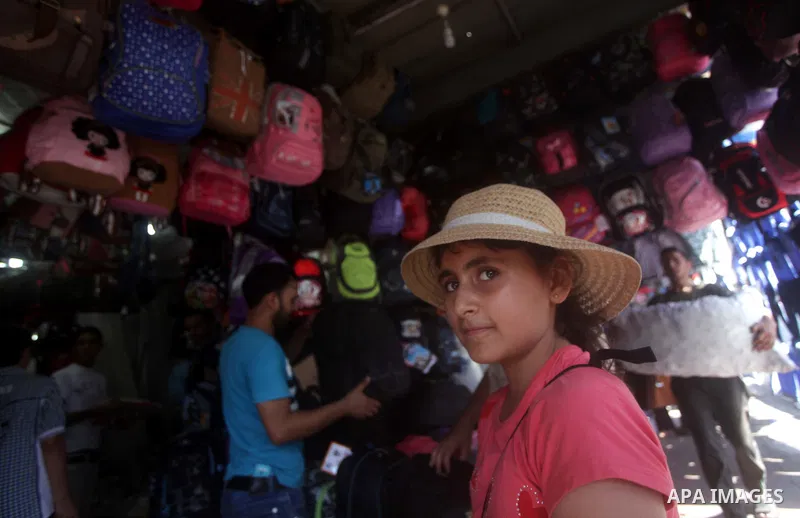 Palestinians shop during preperation for the new school year at a market in Gaza City on Aug 21, 2013. Palestinian Ministry of Education announced the 25 August is the first day of new school year in the West Bank and Ga...