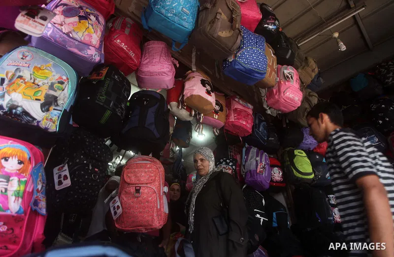 Palestinians shop during preperation for the new school year at a market in Gaza City on Aug 21, 2013. Palestinian Ministry of Education announced the 25 August is the first day of new school year in the West Bank and Ga...