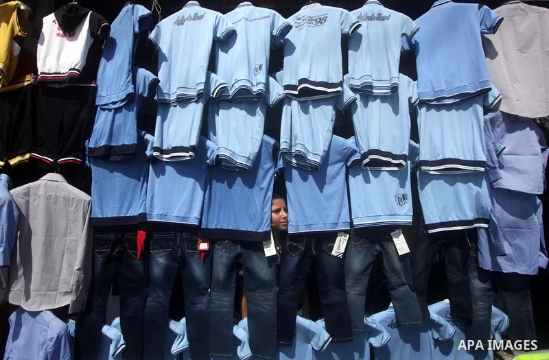 Palestinians shop during preperation for the new school year at a market in Gaza City on Aug 21, 2013. Palestinian Ministry of Education announced the 25 August is the first day of new school year in the West Bank and Ga...