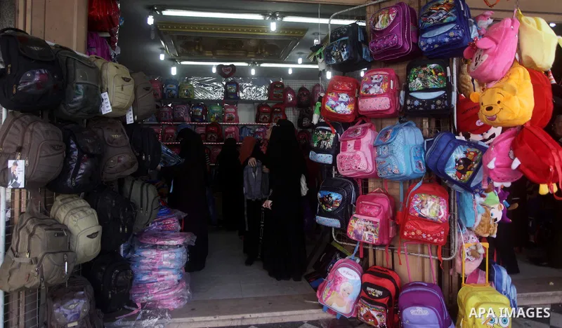 Palestinians shop during preperation for the new school year at a market in Gaza City on Aug 21, 2013. Palestinian Ministry of Education announced the 25 August is the first day of new school year in the West Bank and Ga...