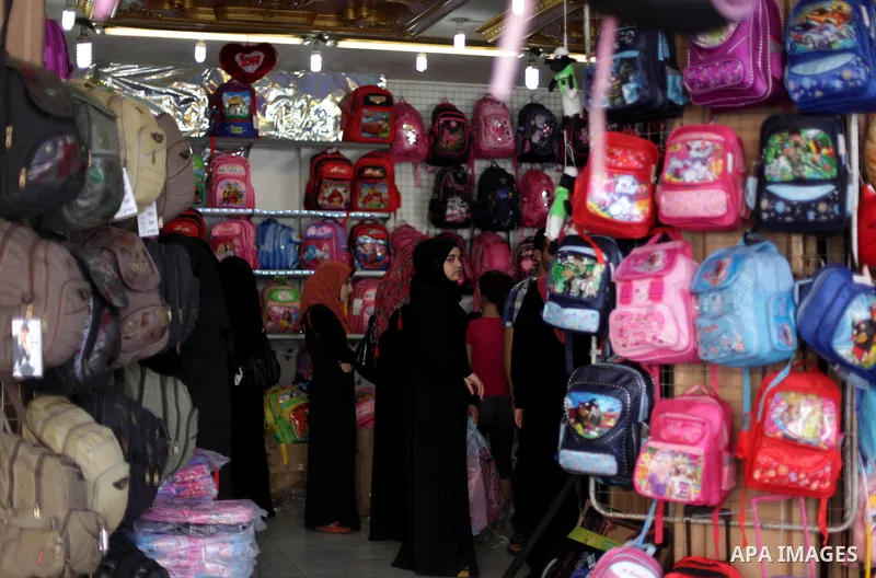 Palestinians shop during preperation for the new school year at a market in Gaza City on Aug 21, 2013. Palestinian Ministry of Education announced the 25 August is the first day of new school year in the West Bank and Ga...