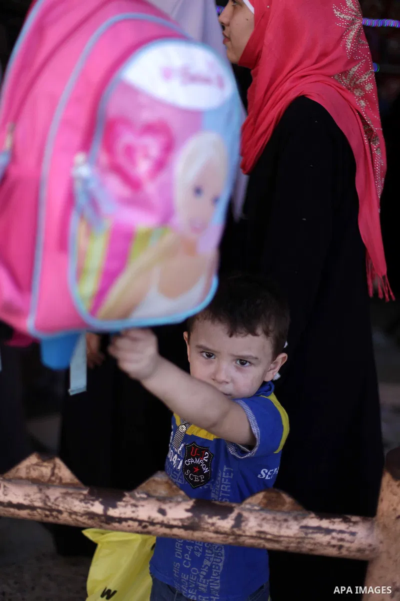 Palestinians shop during preperation for the new school year at a market in Gaza City on Aug 21, 2013. Palestinian Ministry of Education announced the 25 August is the first day of new school year in the West Bank and Ga...