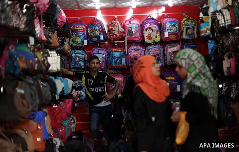 Palestinians shop during preperation for the new school year at a market in Gaza City on Aug 21, 2013. Palestinian Ministry of Education announced the 25 August is the first day of new school year in the West Bank and Ga...