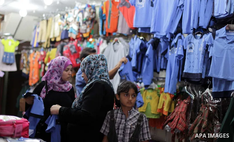 Palestinians shop during preperation for the new school year at a market in Gaza City on Aug 21, 2013. Palestinian Ministry of Education announced the 25 August is the first day of new school year in the West Bank and Ga...