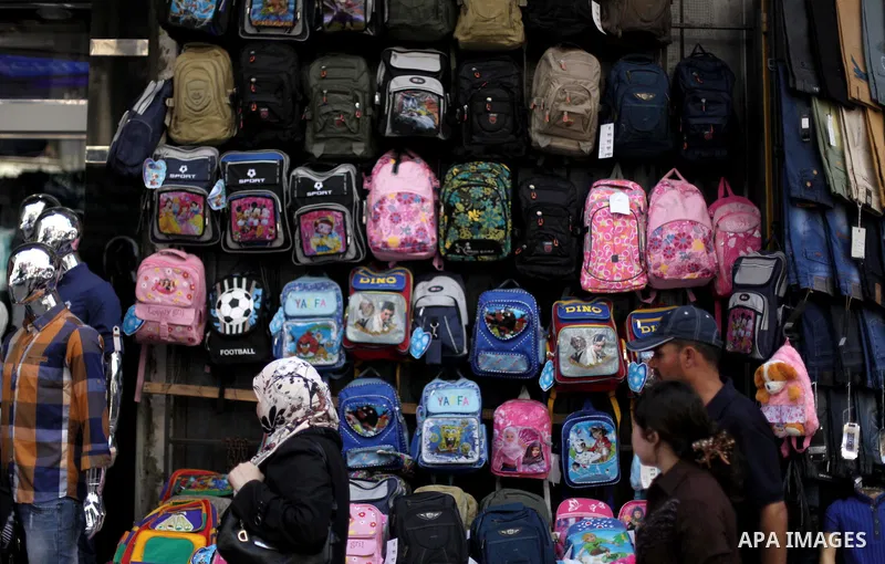 Palestinians shop during preperation for the new school year at a market in Gaza City on Aug 21, 2013. Palestinian Ministry of Education announced the 25 August is the first day of new school year in the West Bank and Ga...