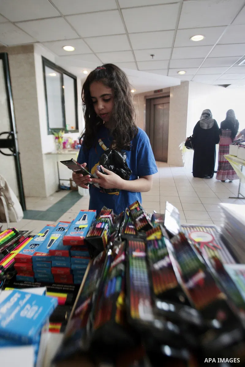 Palestinians shop during preperation for the new school year in the West Bank City of Nablus on Aug 22, 2013. Palestinian Ministry of Education announced the 25 August is the first day of new school year in the West Bank...