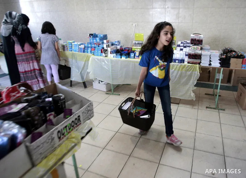 Palestinians shop during preperation for the new school year in the West Bank City of Nablus on Aug 22, 2013. Palestinian Ministry of Education announced the 25 August is the first day of new school year in the West Bank...