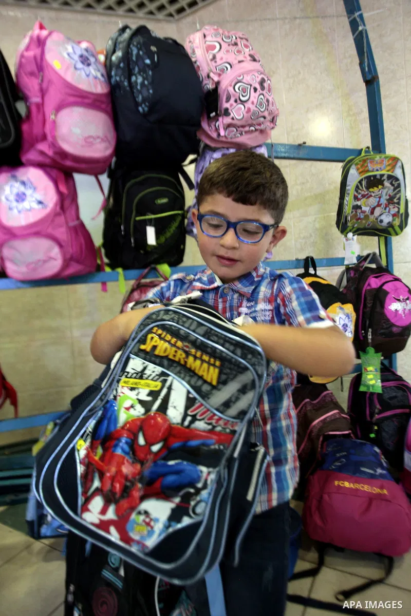 Palestinians shop during preperation for the new school year in the West Bank City of Nablus on Aug 22, 2013. Palestinian Ministry of Education announced the 25 August is the first day of new school year in the West Bank...