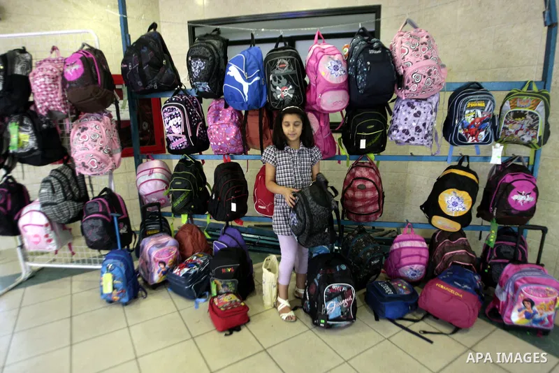 Palestinians shop during preperation for the new school year in the West Bank City of Nablus on Aug 22, 2013. Palestinian Ministry of Education announced the 25 August is the first day of new school year in the West Bank...