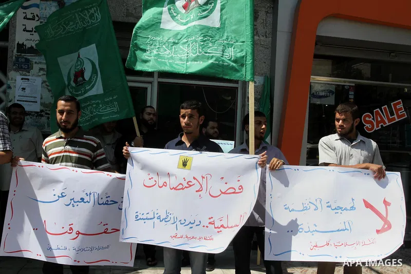 Palestinians hold banners during a protest calling for stop against members of Hamas violence by Ramallah government, in Gaza city on Aug. 22, 2013. Photo by Mohammed Asad
