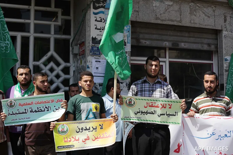 Palestinians hold banners during a protest calling for stop against members of Hamas violence by Ramallah government, in Gaza city on Aug. 22, 2013. Photo by Ashraf Amra