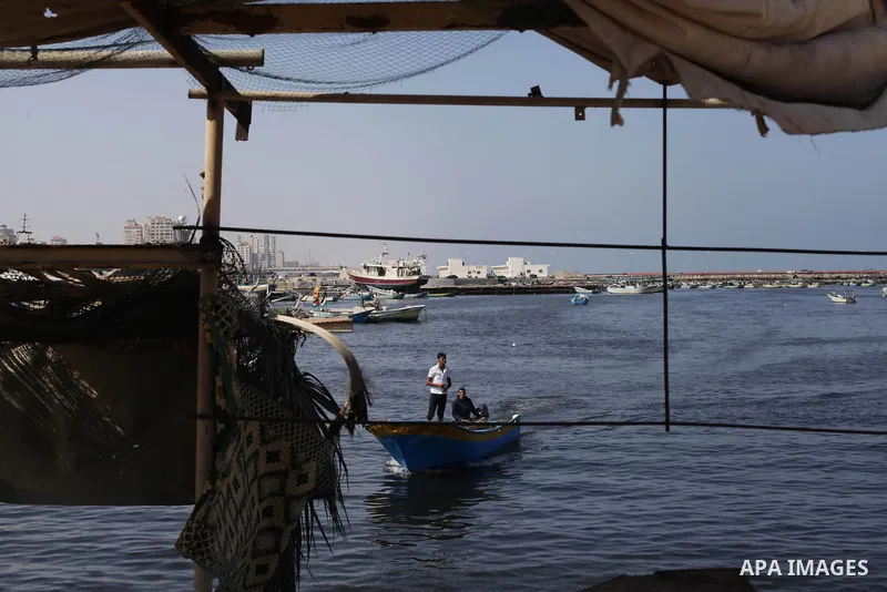 Palestinian fishermen work on their boats during a rally inside the port of Gaza to protest on the Israeli siege on the Gaza Strip and the five-year anniversary of the entry of first two ships solidarity with Gaza, in Ga...