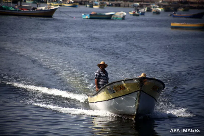 Palestinian fishermen work on their boats during a rally inside the port of Gaza to protest on the Israeli siege on the Gaza Strip and the five-year anniversary of the entry of first two ships solidarity with Gaza, in Ga...