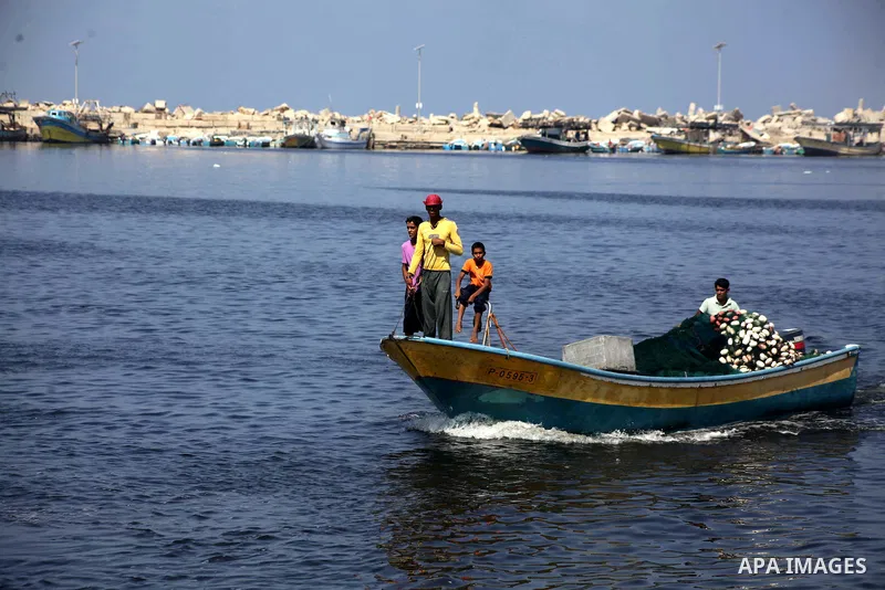 Palestinian fishermen work on their boats during a rally inside the port of Gaza to protest on the Israeli siege on the Gaza Strip and the five-year anniversary of the entry of first two ships solidarity with Gaza, in Ga...