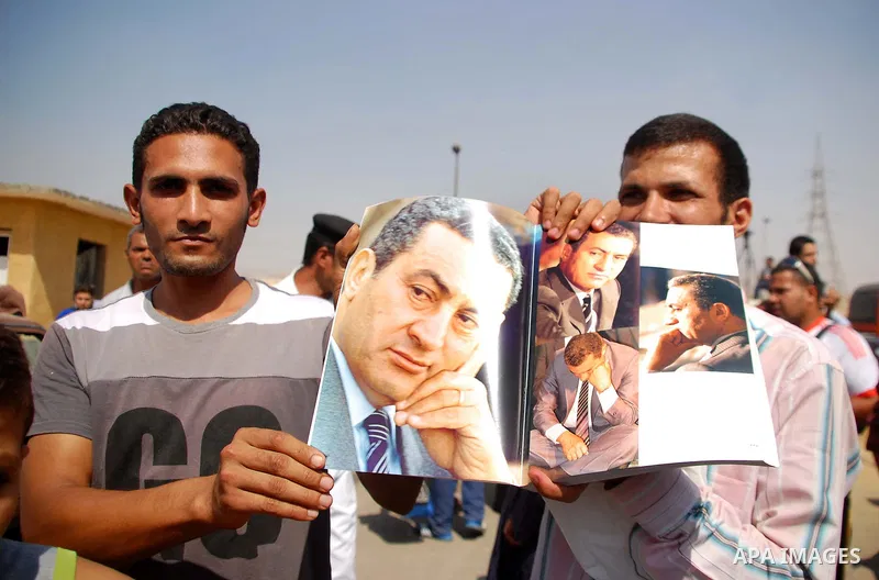 Supporters of Egypt's deposed autocrat Hosni Mubarak hold posters of him and chant slogans in front of Torah Prison, where Egypt's deposed autocrat Hosni Mubarak has been held, in Cairo, Egypt, Thursday, Aug. 22, 2013. E...