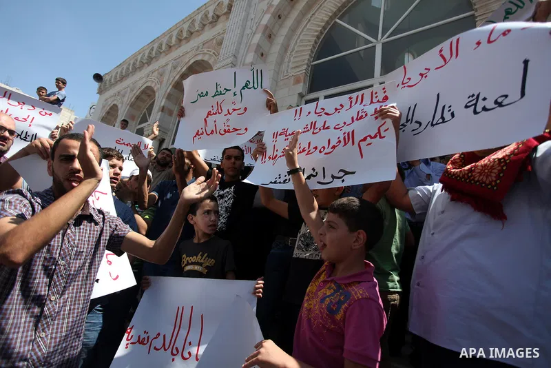 Palestinians raise their hands and four fingers, a sign that protesters say symbolizes the Rabaah al-Adawiya mosque in Cairo that was cleared last week by Egyptian security forces, during a rally in support of the ousted...