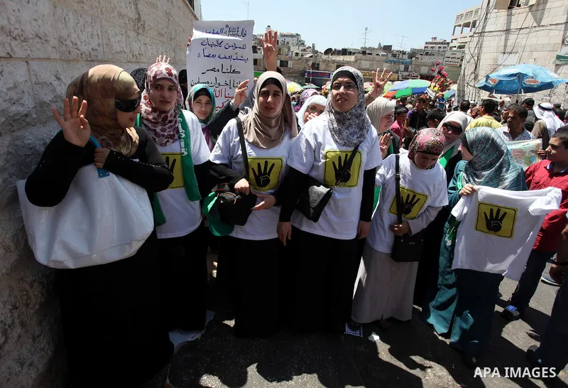 Palestinian girls raise their hands and four fingers, a sign that protesters say symbolizes the Rabaah al-Adawiya mosque in Cairo that was cleared last week by Egyptian security forces, during a rally in support of the o...