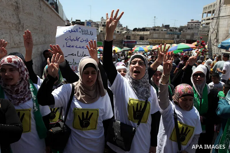 Palestinian girls raise their hands and four fingers, a sign that protesters say symbolizes the Rabaah al-Adawiya mosque in Cairo that was cleared last week by Egyptian security forces, during a rally in support of the o...