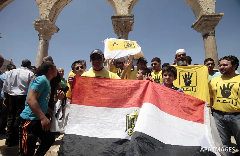Palestinian supporters of the radical Islamist movement Hamas raise their hands and four fingers, a sign that protesters say symbolizes the Rabaah al-Adawiya mosque in Cairo that was cleared last week by Egyptian securit...