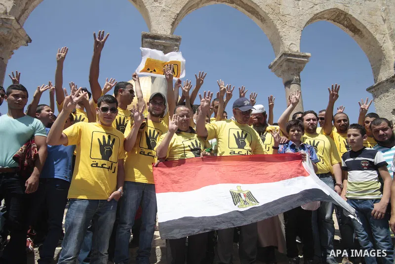 Palestinian supporters of the radical Islamist movement Hamas raise their hands and four fingers, a sign that protesters say symbolizes the Rabaah al-Adawiya mosque in Cairo that was cleared last week by Egyptian securit...