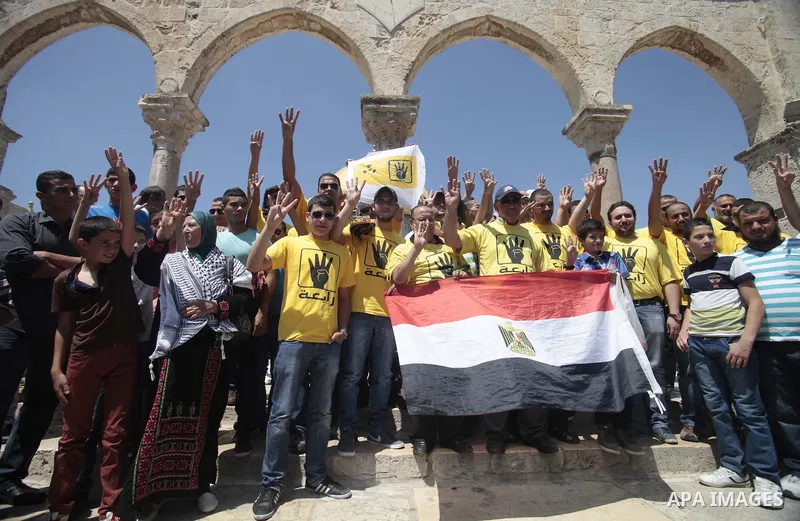 Palestinian supporters of the radical Islamist movement Hamas raise their hands and four fingers, a sign that protesters say symbolizes the Rabaah al-Adawiya mosque in Cairo that was cleared last week by Egyptian securit...