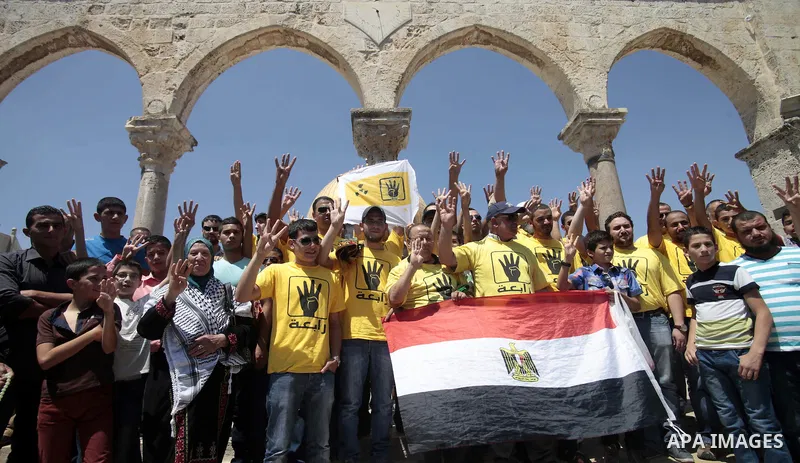 Palestinian supporters of the radical Islamist movement Hamas raise their hands and four fingers, a sign that protesters say symbolizes the Rabaah al-Adawiya mosque in Cairo that was cleared last week by Egyptian securit...