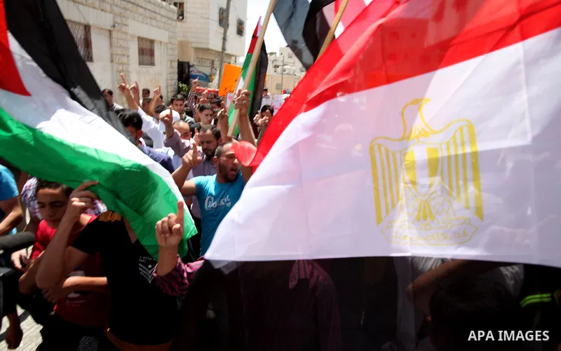 Palestinian protesters hold Egyptian and Palestinian flags during a rally in support of Egypt's deposed president Mohamed Morsi, in the controlled Israeli enclave called H2, in the West Bank town of Hebron on August 23,...
