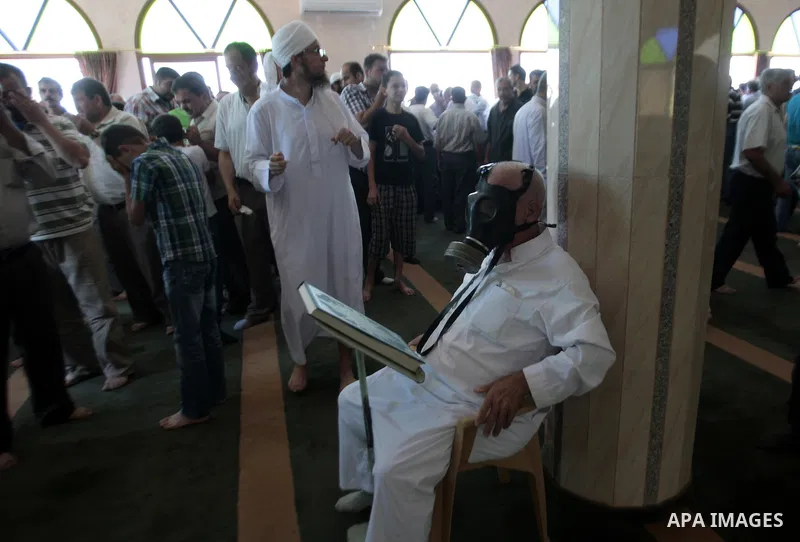 Palestinian worshipers cover their faces after inhaling tear gas fired by Israeli security forces at a mosque during Friday prayer in the village of Kfar Qaddum, near Nablus in the occupied West Bank on August 13, 2013....