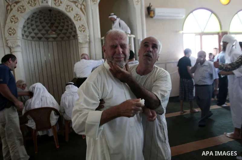 Palestinian worshipers cover their faces after inhaling tear gas fired by Israeli security forces at a mosque during Friday prayer in the village of Kfar Qaddum, near Nablus in the occupied West Bank on August 13, 2013....