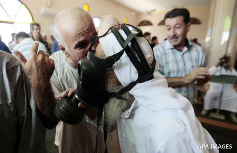 Palestinian worshipers cover their faces after inhaling tear gas fired by Israeli security forces at a mosque during Friday prayer in the village of Kfar Qaddum, near Nablus in the occupied West Bank on August 13, 2013....