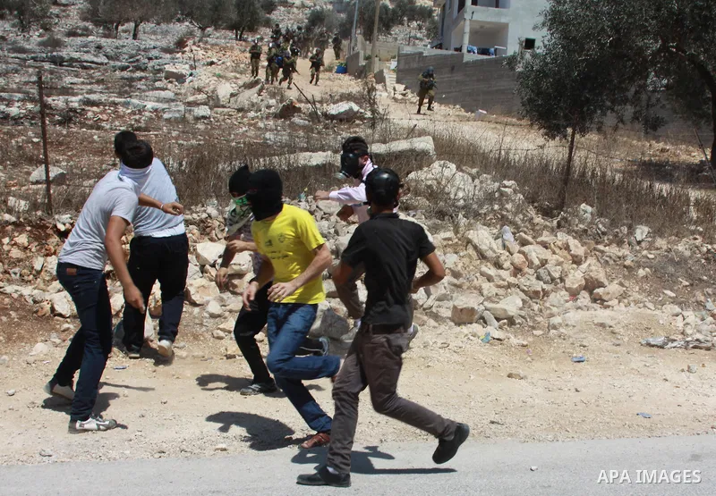 Palestinian protesters throw stones at Israeli security forces during clashes following a protest against the expropriation of Palestinian land by Israel in the village of Kfar Qaddum, near Nablus in the occupied West Ba...