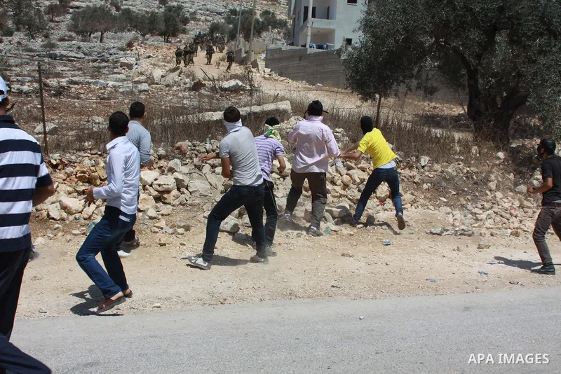 Palestinian protesters throw stones at Israeli security forces during clashes following a protest against the expropriation of Palestinian land by Israel in the village of Kfar Qaddum, near Nablus in the occupied West Ba...