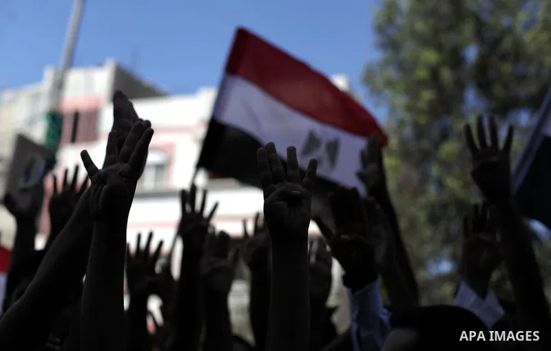Palestinians hold Egyptian national flags, posters of ousted Egyptian President Mohamed Morsi and logos of four fingers, during a demonstration to support Morsi and denounce Syria's President Bashar al-Assad, in Al-Nusir...