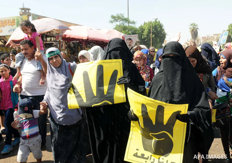 Egyptians supporters of ousted president Morsi hold posters depicting him and others depicting a hand in a sign of the number four during a Friday protest called for by the Muslim Brotherhood in Helwan, Egypt, 23 August...